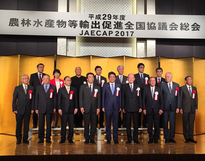 安倍晋三首相（左から５人目）と記念撮影に臨む八木秀峰社長（前列左端）ら＝11月24日、東京都内（提供写真）
