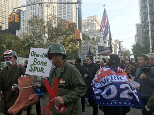 トランプ氏を揶揄する「Bone Spur（骨棘、こつきょく）」のプラカードを掲げる反対派と、「TRUMP 2020」の旗を背負う支持派＝11日、ニューヨーク（撮影：田部井）