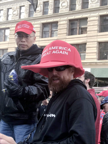 トランプ氏のスローガン「MAKE AMERICA GREAT AGAIN（アメリカを再び偉大な国に）」の帽子を被る支持派＝11日、ニューヨーク（撮影：田部井）