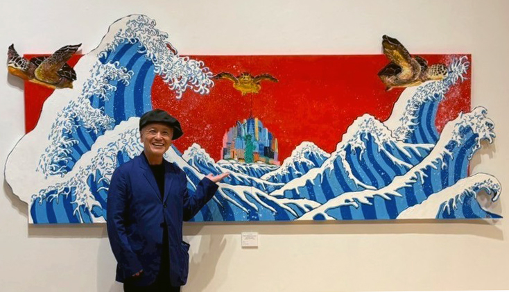 作品を前に笑顔で撮影に応じる画家の河村武明TAKEさん=5月16日、ニューヨーク天理ギャラリー(撮影:森田)