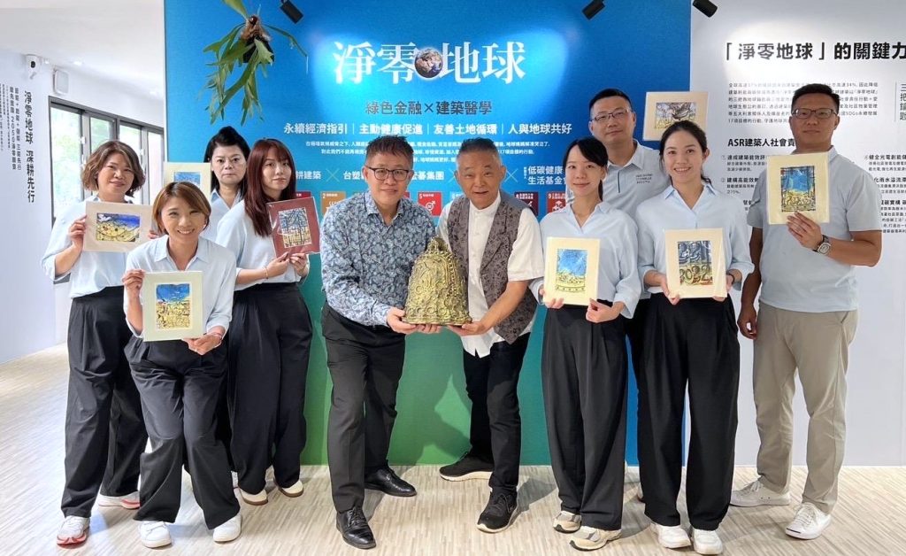 張水田氏（写真中央左）と筆者（写真中央右）と冠竑建設会社の皆さん。手にしているのは「平和の鐘」の模型